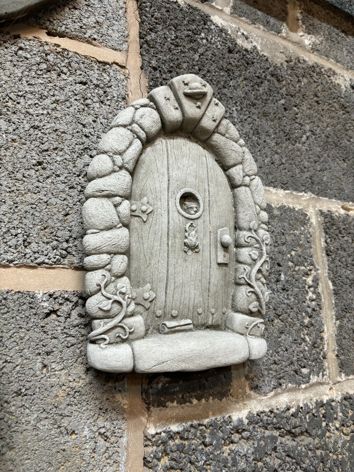 Side view of Stone Fairy Door Plaque showing 3D carved stone texture and whimsical design, perfect for outdoor wall or tree mounting.