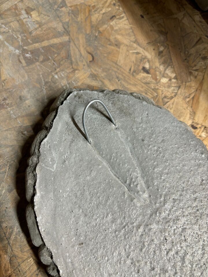 Back of Stone Fairy Door Plaque showing metal hanging hook for easy wall or tree installation, made from solid limestone for durability.