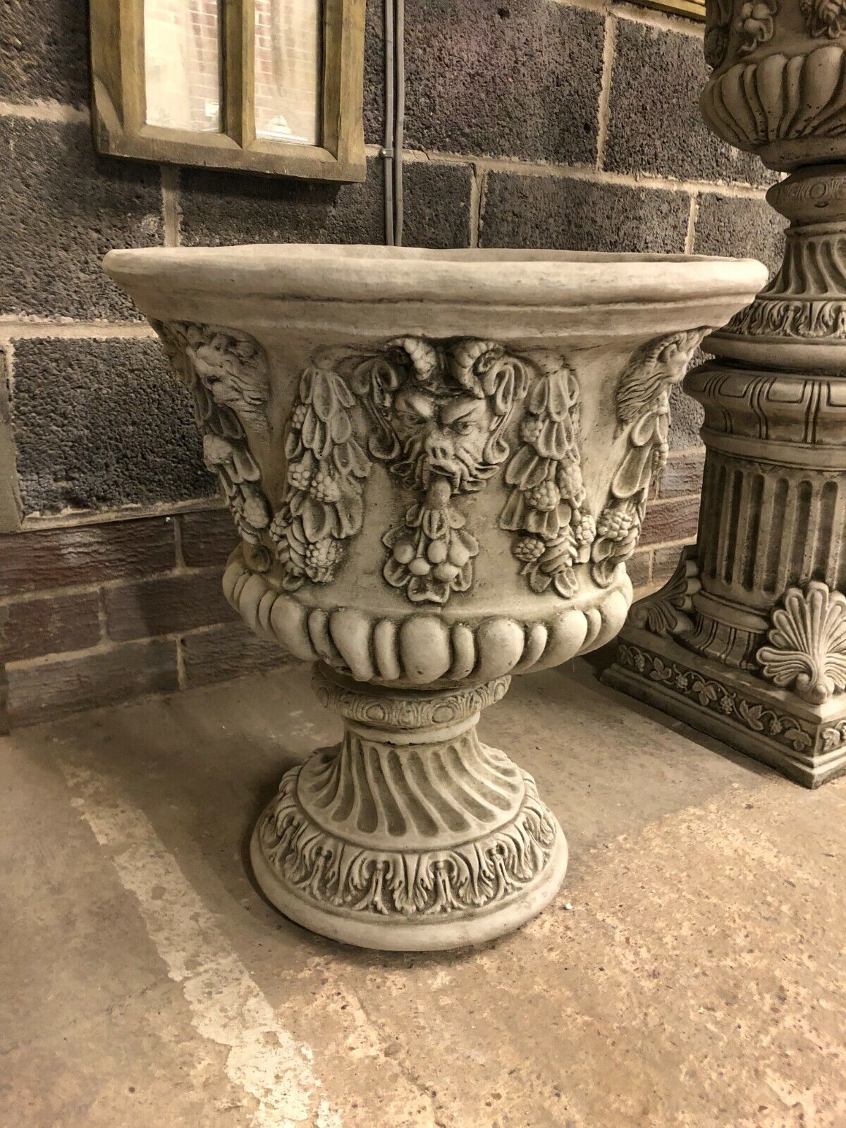 Large Stone Bacchus Garden Planter with weatherproof antique finish, featuring ornate Greco-Roman deity face and garland detailing on stone base.
