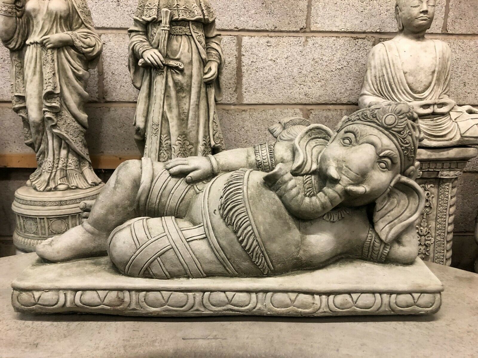 Ganesh Garden Statue in laying down pose, crafted from durable stone with intricate detailing. Ideal for outdoor garden or patio decor.