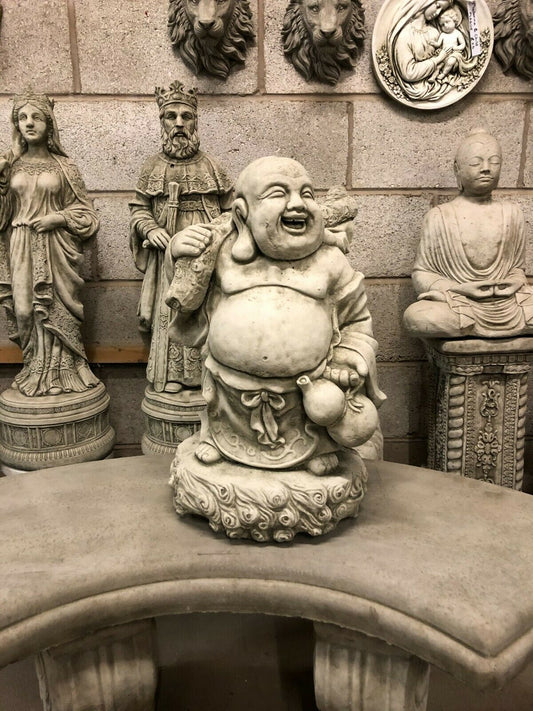 Stone Laughing Buddha Statue - Weather Resistant | Antique Finish, placed on a curved stone bench with detailed carvings, ideal for garden decor.
