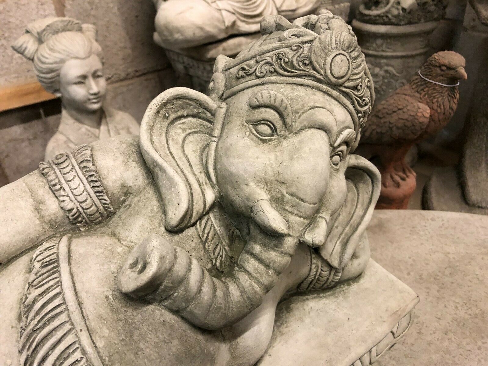 Close-up of Ganesh Garden Statue's face and crown, highlighting fine stone carving and serene expression for spiritual garden ambiance.