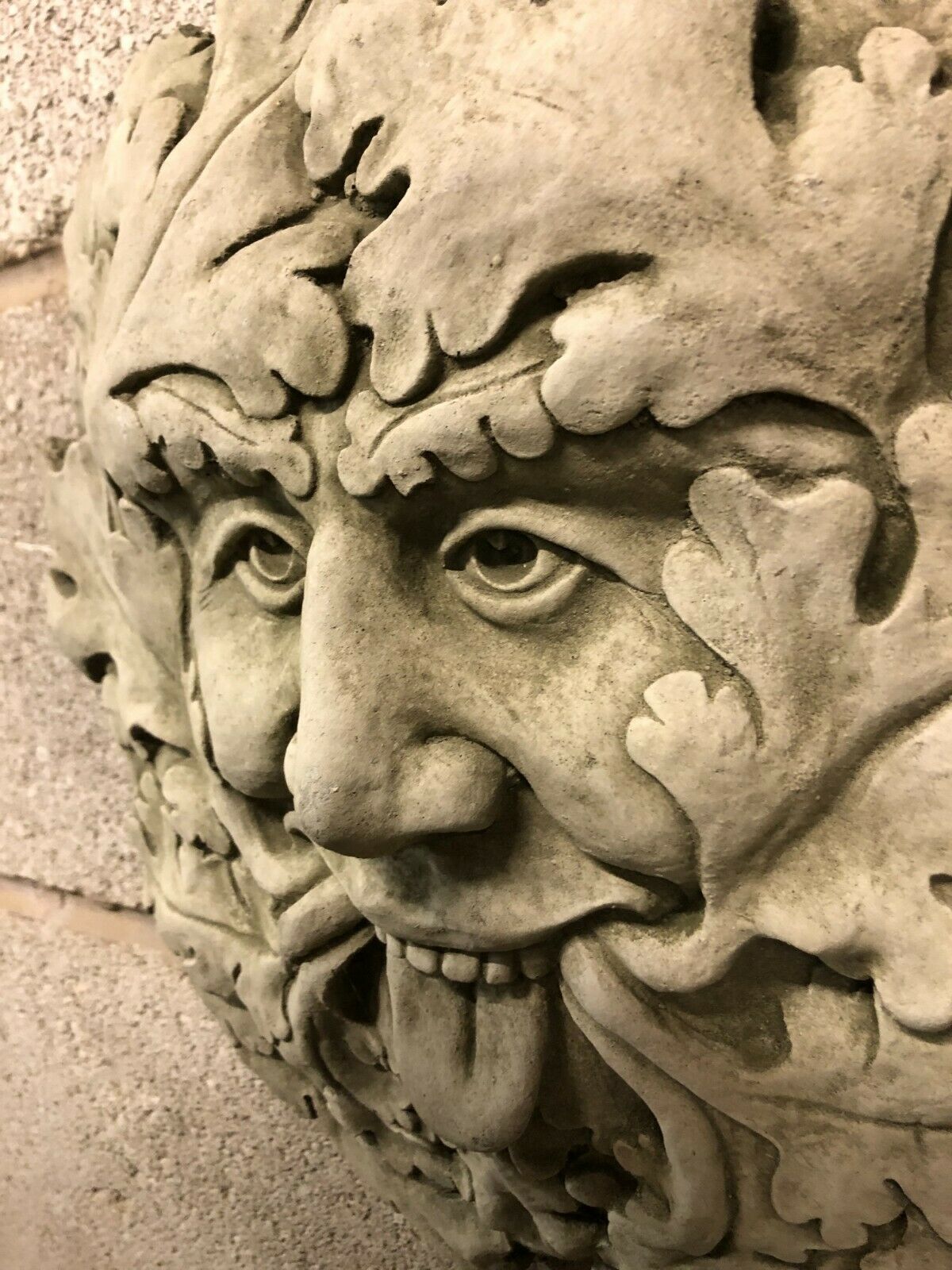 Close-up of Stone Tongue Out Greenman Plaque showing detailed facial features and textured oak leaf pattern, ideal for garden or patio decoration.