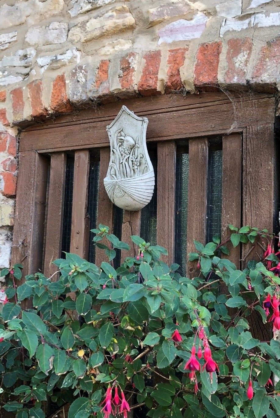 Stone Rabbit Planter displayed above garden flowers, enhancing outdoor decor with its charming animal-themed design.