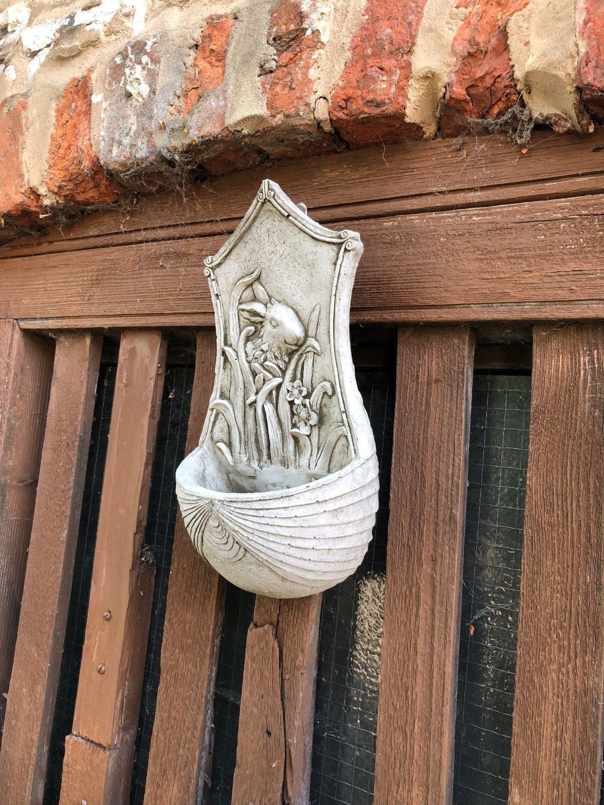 Side angle of Stone Rabbit Planter showing curved bowl and sculpted bunny, ideal for small plants or herbs in garden settings.