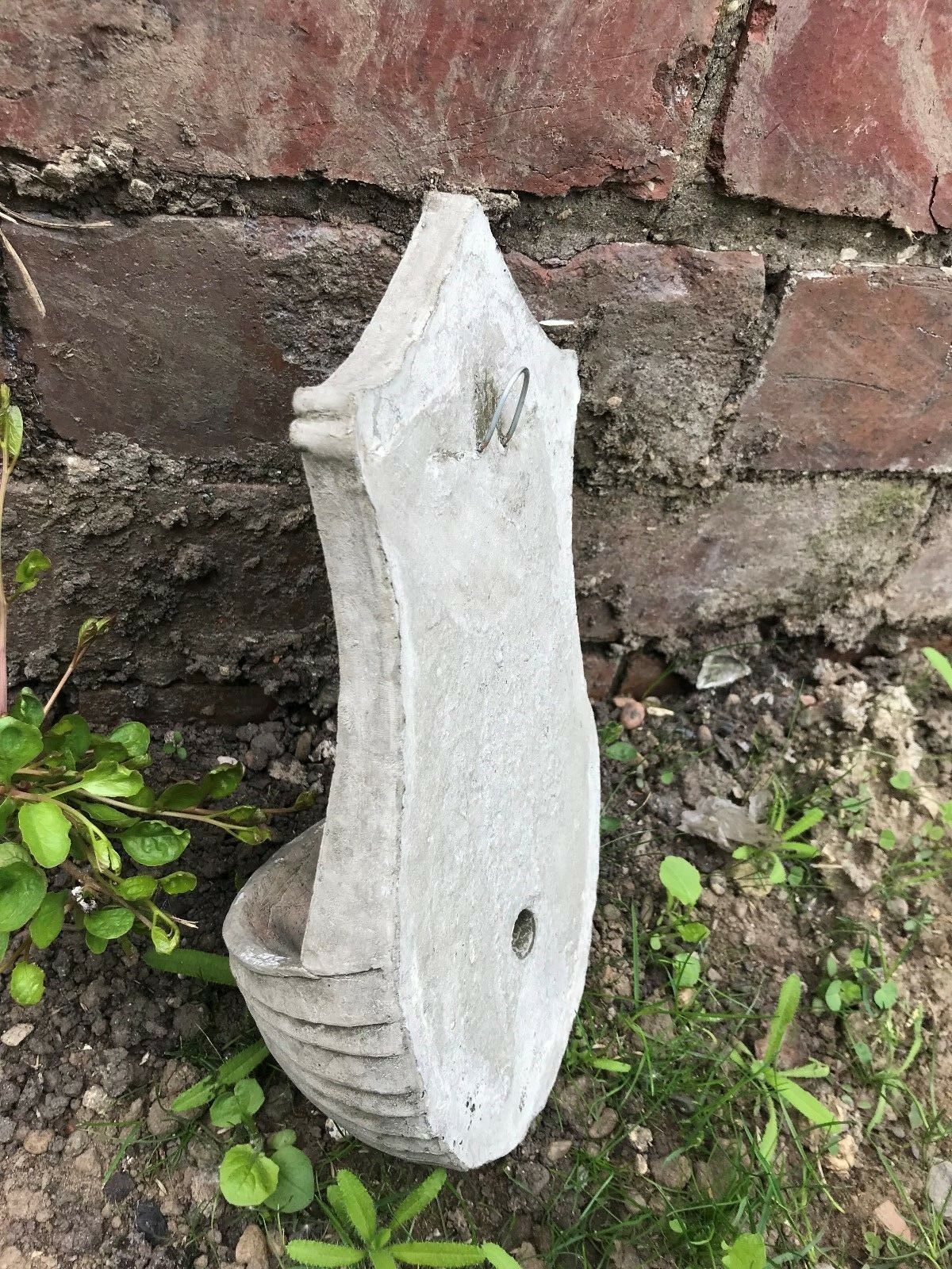 Angled rear view of Stone Rabbit Planter highlighting its solid stone construction and mounting hardware for outdoor use.