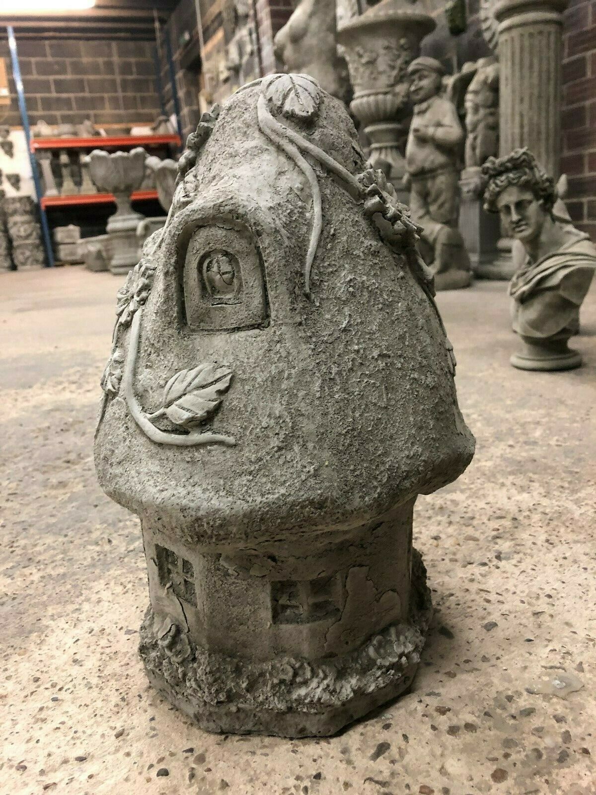 Back view of Stone Cottage Ornament showing sculpted leaves and window details, designed for enchanting garden landscapes with durable limestone material.