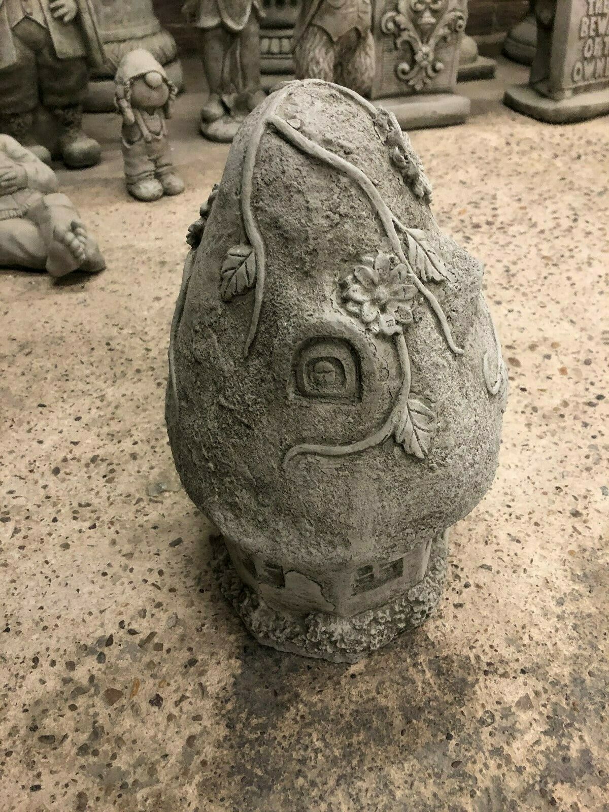 Side view of Magical Stone Cottage Ornament with curved roof and floral carvings, made from crack-resistant limestone for garden decoration.