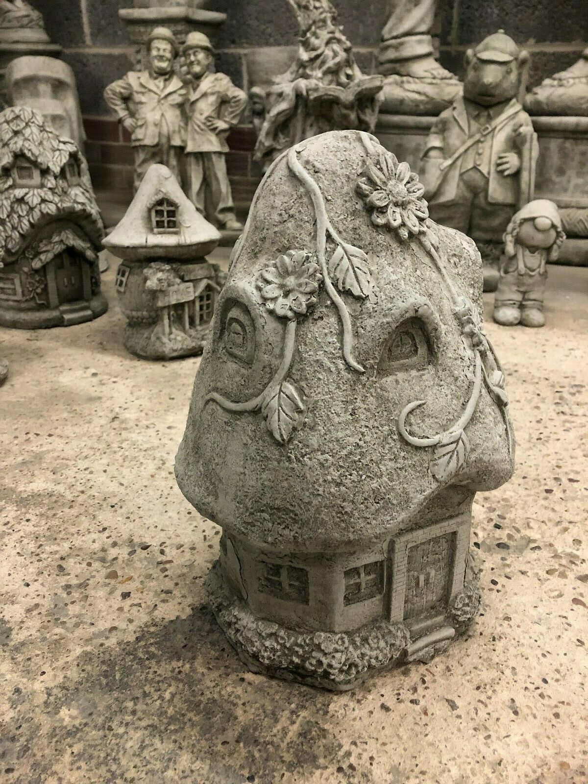 Front angle of Stone Cottage Ornament with detailed door, windows, and climbing vines, ideal for whimsical garden decor in all weather conditions.