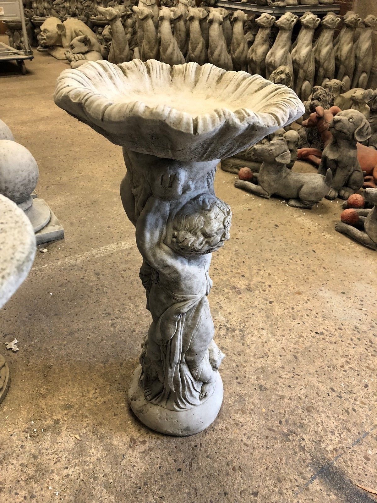 Elegant Stone Cherub Garden Bird Bath with antique finish, featuring twin cherubs supporting a large bird basin, suited for classic garden décor.