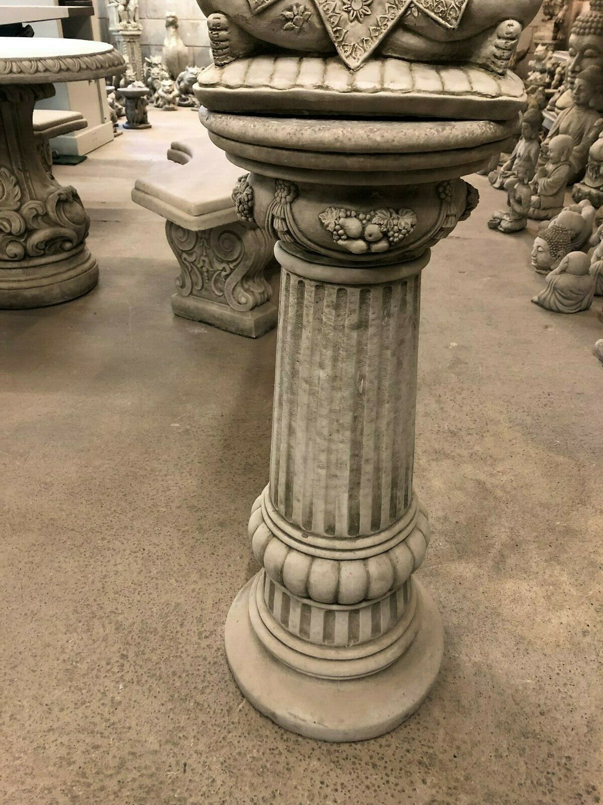 Mid-section of Stone Buddha Bust - Garden Ornament's plinth with vertical grooves and ornate fruit carvings, enhancing garden elegance.