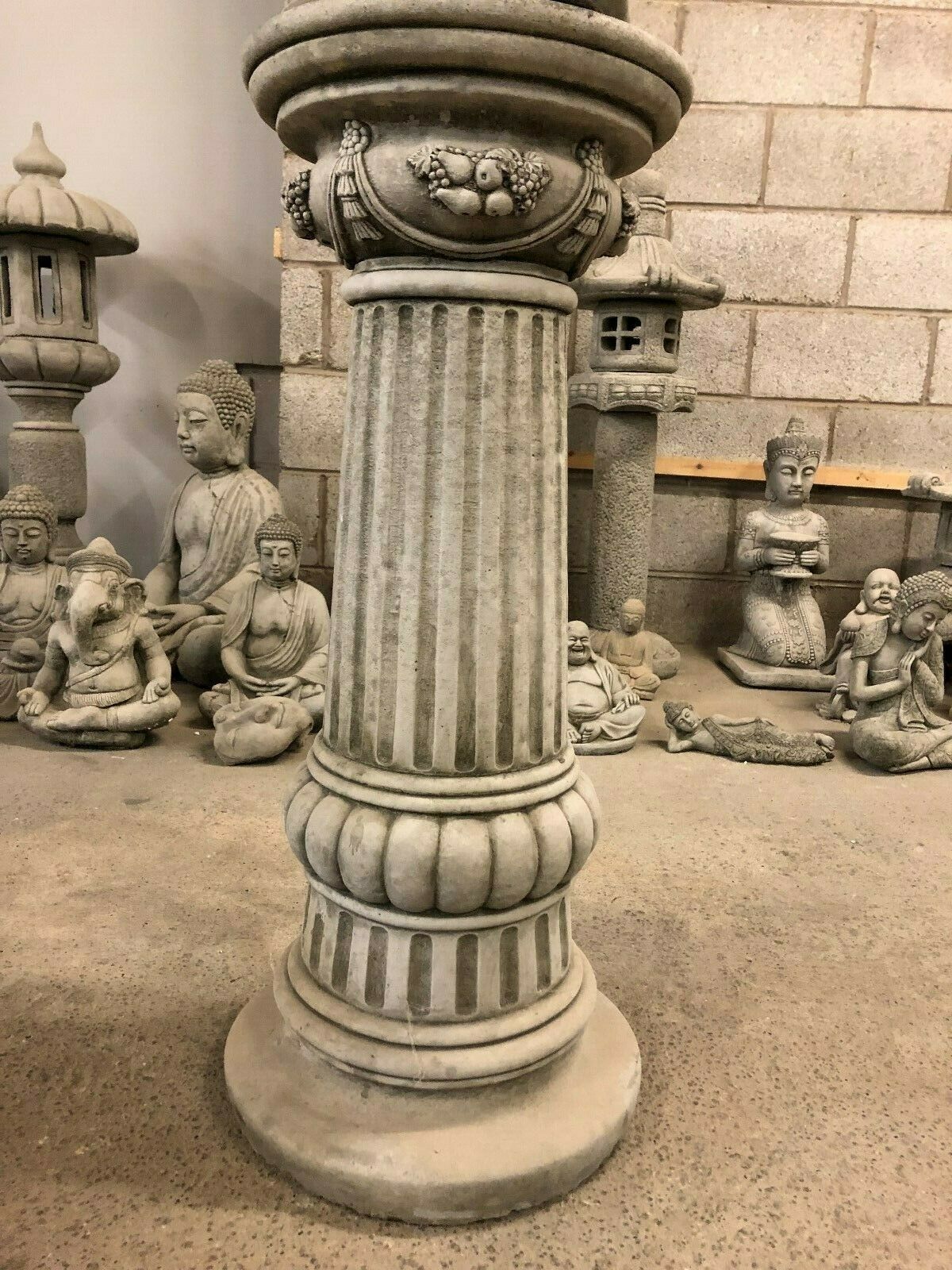 Lower section of Stone Buddha Bust - Garden Ornament's pedestal with rounded base and classical column design, ideal for outdoor decor.