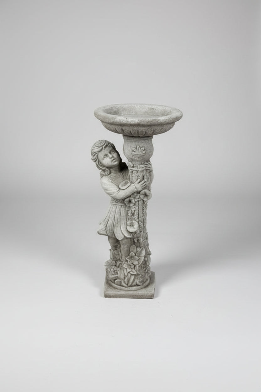 Decorative stone pedestal with angel design on a concrete floor